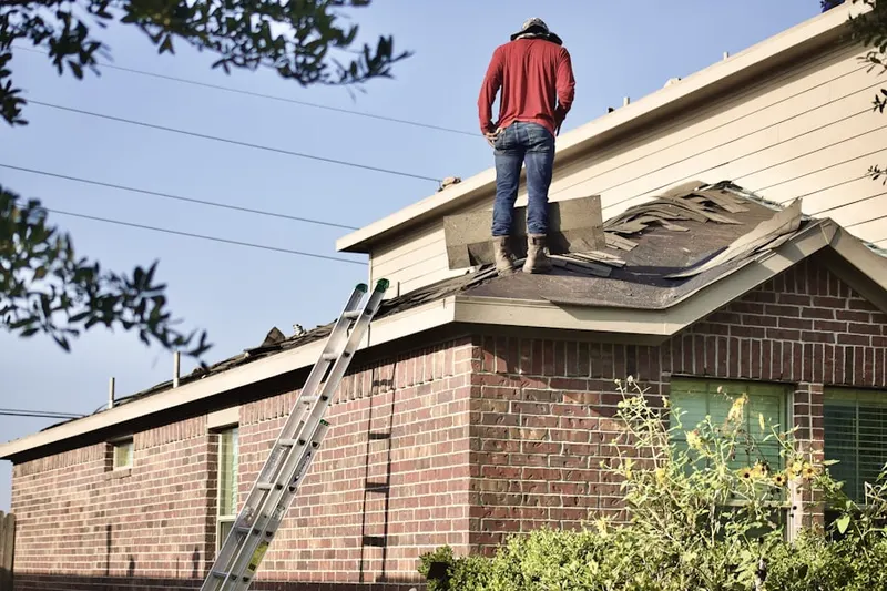 Professional roofer working on a residential roof in Rowayton